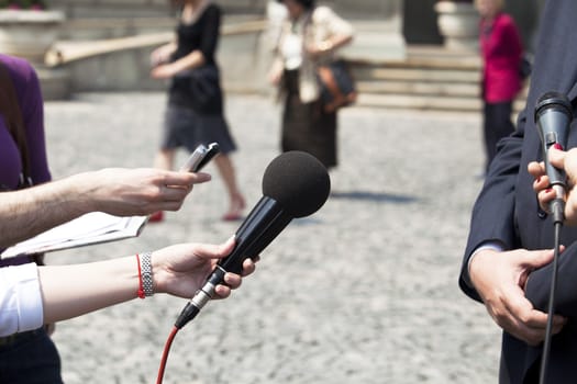 Interview with media microphone held in front of businessman, spokesman or politician