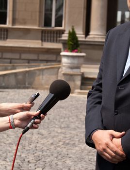 Interview with media microphone held in front of businessman, spokesman or politician