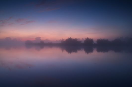 tranquil misty sunrise on wild lake, Drenthe, Netherlands
