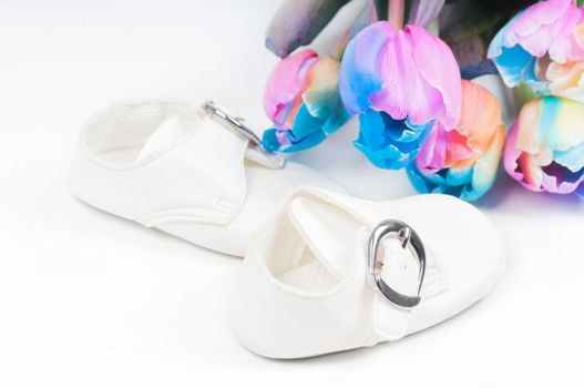 Unusual multi colored tulips and white baby shoes