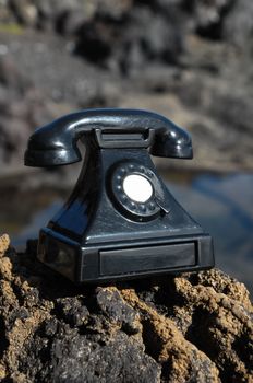 International Communications Vintage Telephone Toy on the Volcanic Rocks