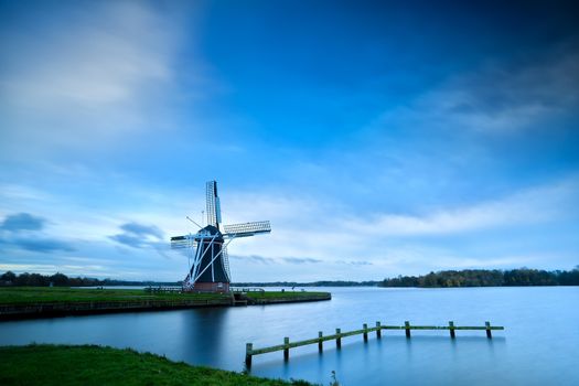 Dutch windmill by lake with long exposure, Groningen, Netherlands