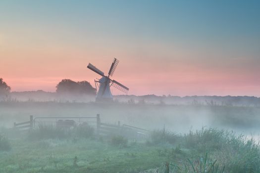 Dutch windmill in summer morning fog, Holland