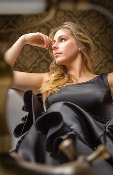 Portrait of beautiful fashion girl with black spanish flamenco dress posing in a vintage bathtub