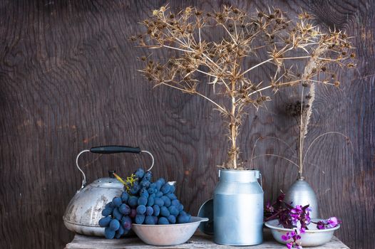 Kitchen utensils on the wooden background with dry autumn prairie flowers