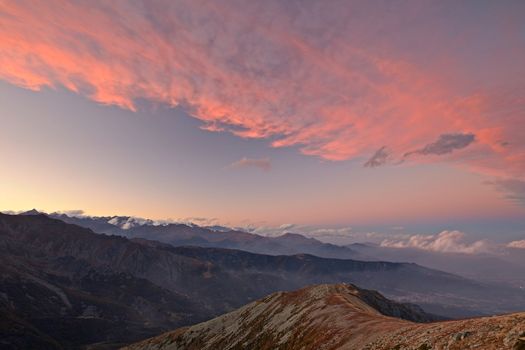 Alpine landscape and romantic cloudscape at sunset in the italian Alps.