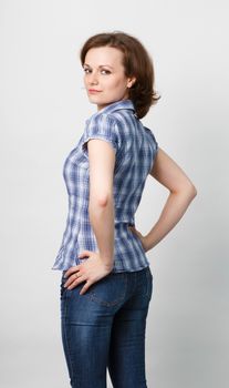 standing girl in a plaid shirt and jeans