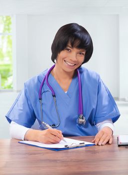 asian female doctror writting and sitting at table