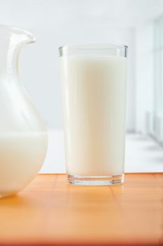 glass of milk and pitcher on table