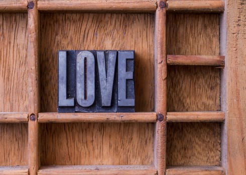 Metal letterpress in an old typesetter's drawer showing the word "LOVE"