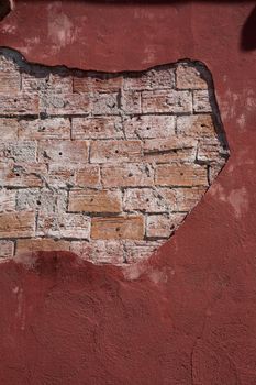 Old brick wall with ragged plaster 