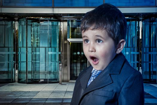 Education, child dressed businessman with hands in his tie and skyscrapers in the background