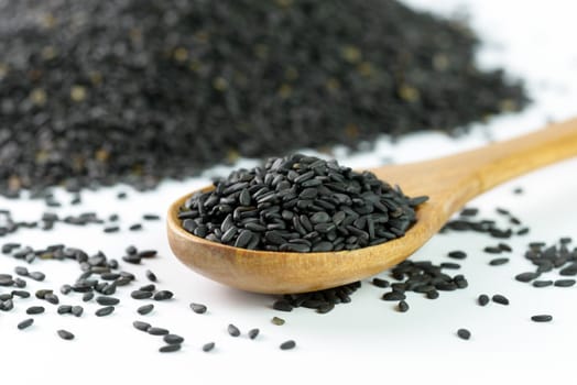 Heap of black sesame on wooden spoon