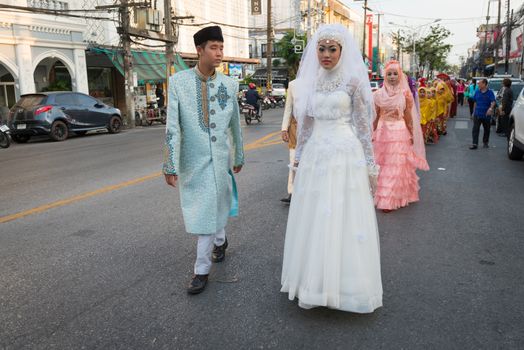 PHUKET, THAILAND - 07 FEB 2014: Phuket town residents in wedding dress take part in procession parade of annual old Phuket town festival. 