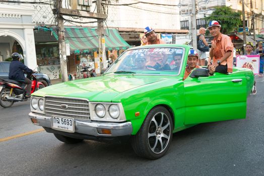 PHUKET, THAILAND - 07 FEB 2014: Phuket town residents on green car take part in procession of annual old Phuket town festival. 