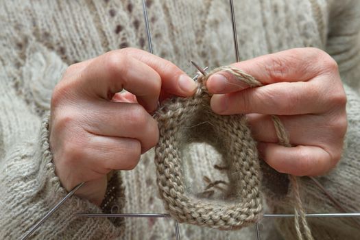 closeup of female hands knitting wool socks