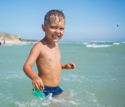 Cute happy smiling boy on beach vacation