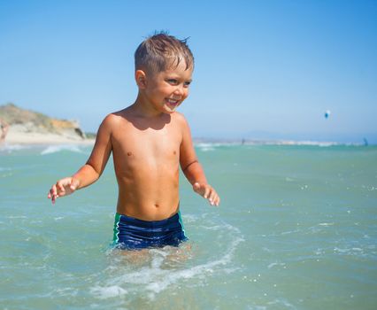 Cute happy smiling boy on beach vacation
