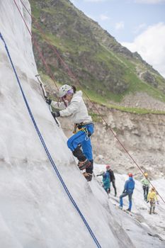 Girl climb up on the ice at glacier