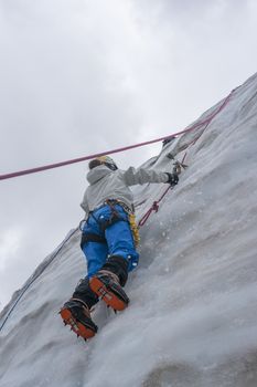 Girl climb up on the ice at glacier