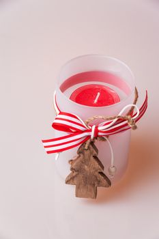 Christmas in candlelight as decoration with ribbon and a small Christmas tree made ​​of wood at the front