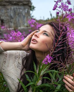 Portrait of beautiful freckled girl among the flowers.