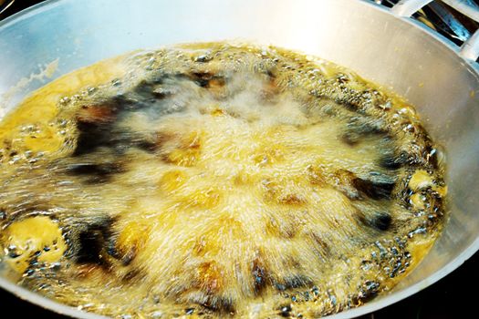 Boiling oil in pan at market