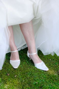 Beautiful leg of the young bride standing in the grass