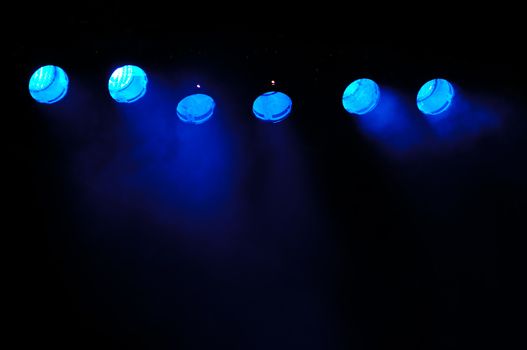 Lights and smoke. Row of blue lights from a stage.