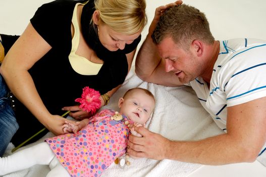 Mother and father are looking at their sweet smiling 4 month old baby.