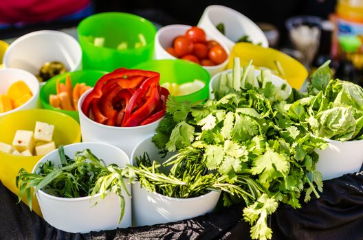 Salad ingredients with lettuce, tomatoes, cucumbers, and cheese.