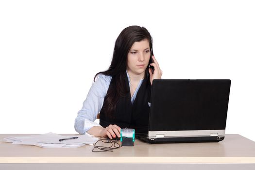 Young woman behind a desk phone and working at laptop, isolated on white background