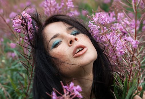 Portrait of beautiful freckled girl among the flowers.