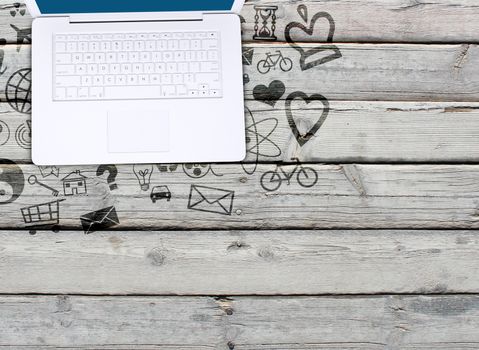 Laptop on an old wooden surface and social icons. Computer technology concept