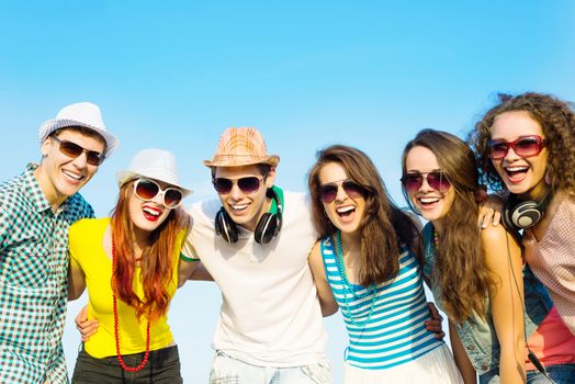 group of young people wearing sunglasses and hats hugging and standing in a row, spending time with friends