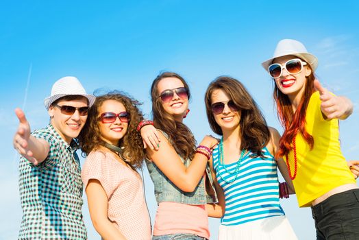 group of young people wearing sunglasses and hats hugging and standing in a row, spending time with friends