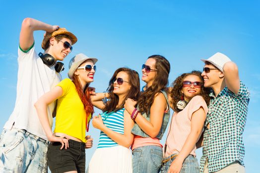 group of young people wearing sunglasses and hats hugging and standing in a row, spending time with friends