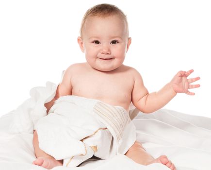 Smiling baby sitting wrapped in towel. Isolated on a white Backgraund