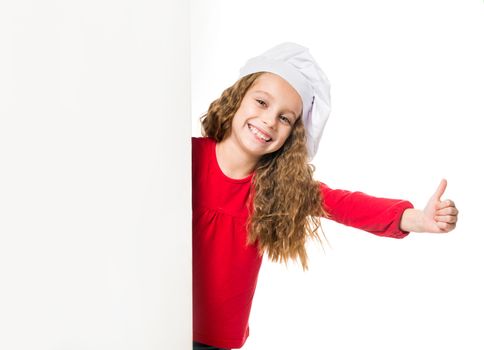 little girl in chef hat with a white board shows thumbs up