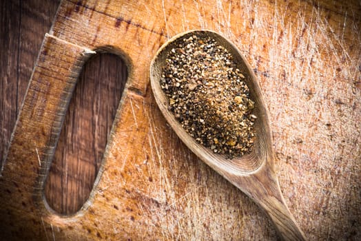 spices in a wooden spoon on a cutting board