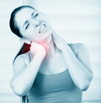 young brunette woman with a pain in the neck, monochrome photo with red as a symbol for the hardening