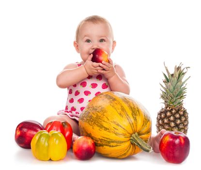 Baby girl sitting surrounded by vegetables and fruits. Isolated on white