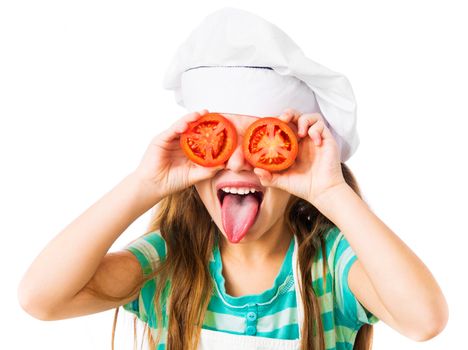 little girl in chef hat with tomatoes near the eye shows tongue