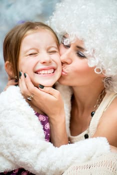 beautiful girl with white curly hair kissing her daughter