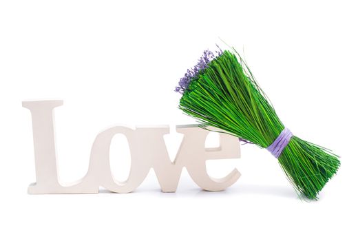 Sign of love with a bunch of green grass with purple flowers. Isolated on white