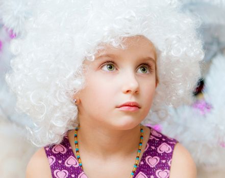 beautiful little girl in a white curly wigs