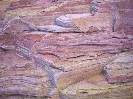 Sandstone erodes in pink and yellow layers