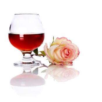 Glass and rose. Alcohol and flower. Glass with drink and a pink rose.