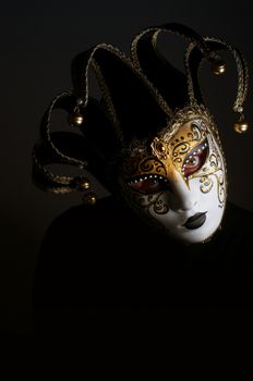 a portrait with Jester mask on black background