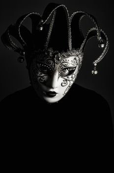 a portrait with Jester mask on black background